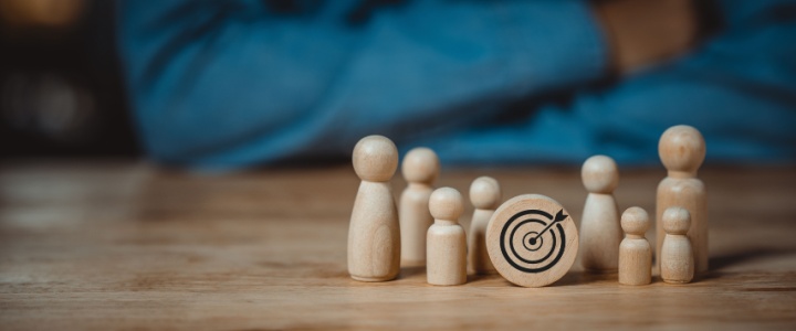 Wooden figures surrounding a wooden target