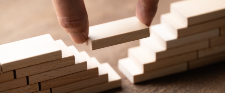 A hand placing a wooden block to bridge a gap