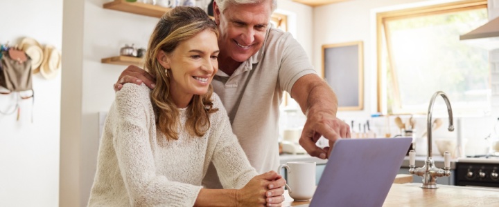 A happy couple looking at a laptop